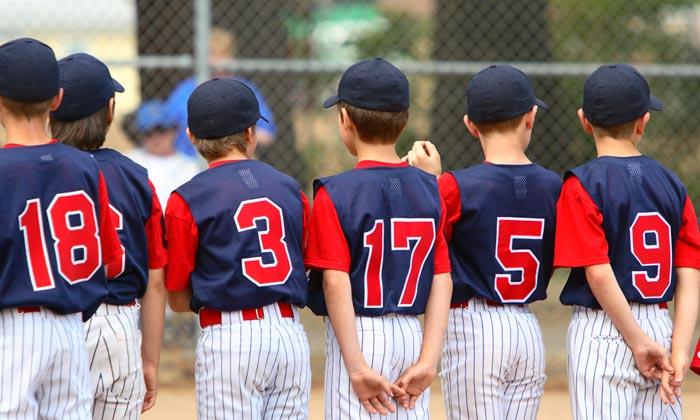 line of boys in little league uniforms from the back
